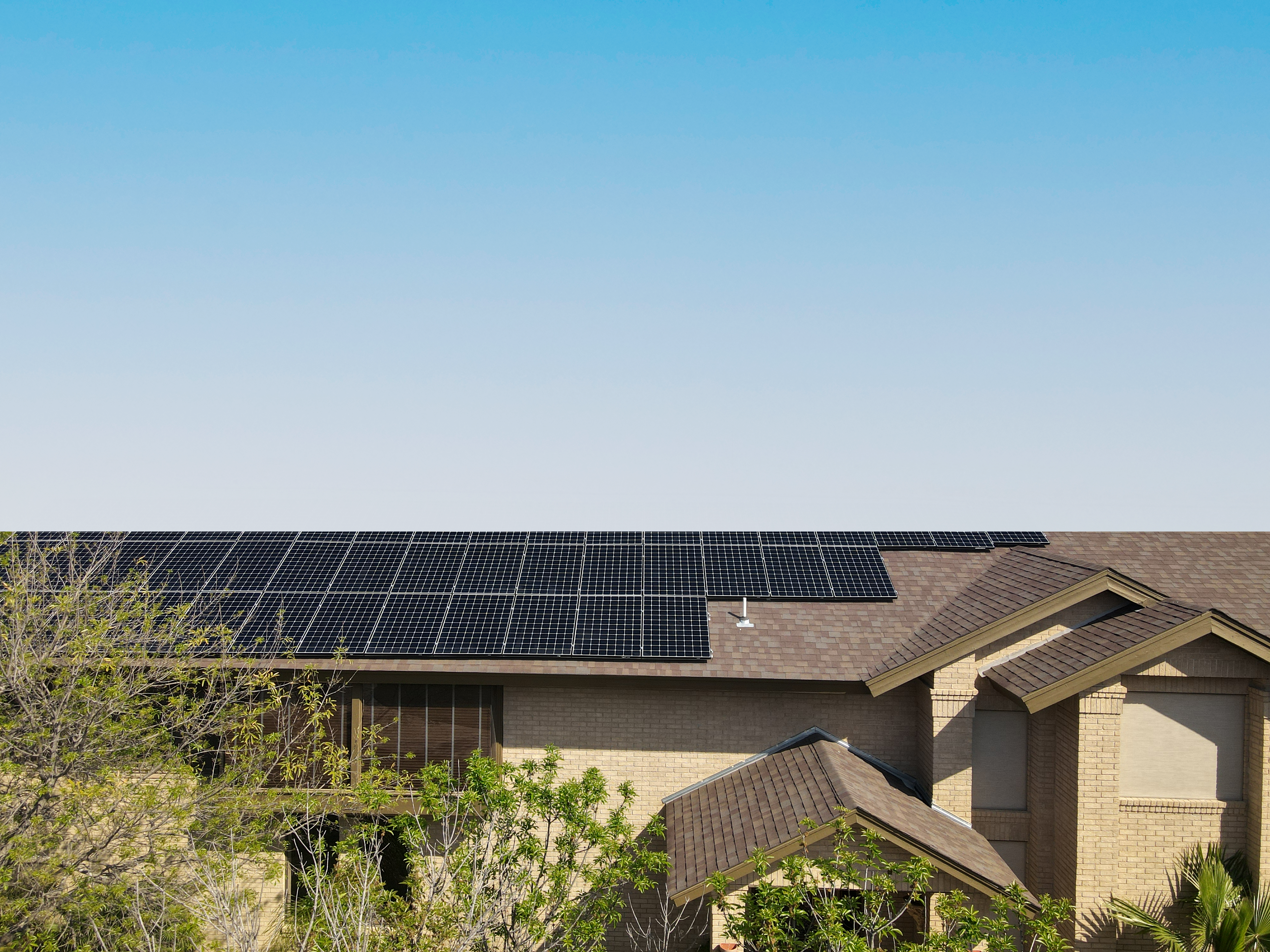 Home in South Texas equipped with solar panels on the roof, provided by PEG Energy, showcasing renewable energy solutions.
